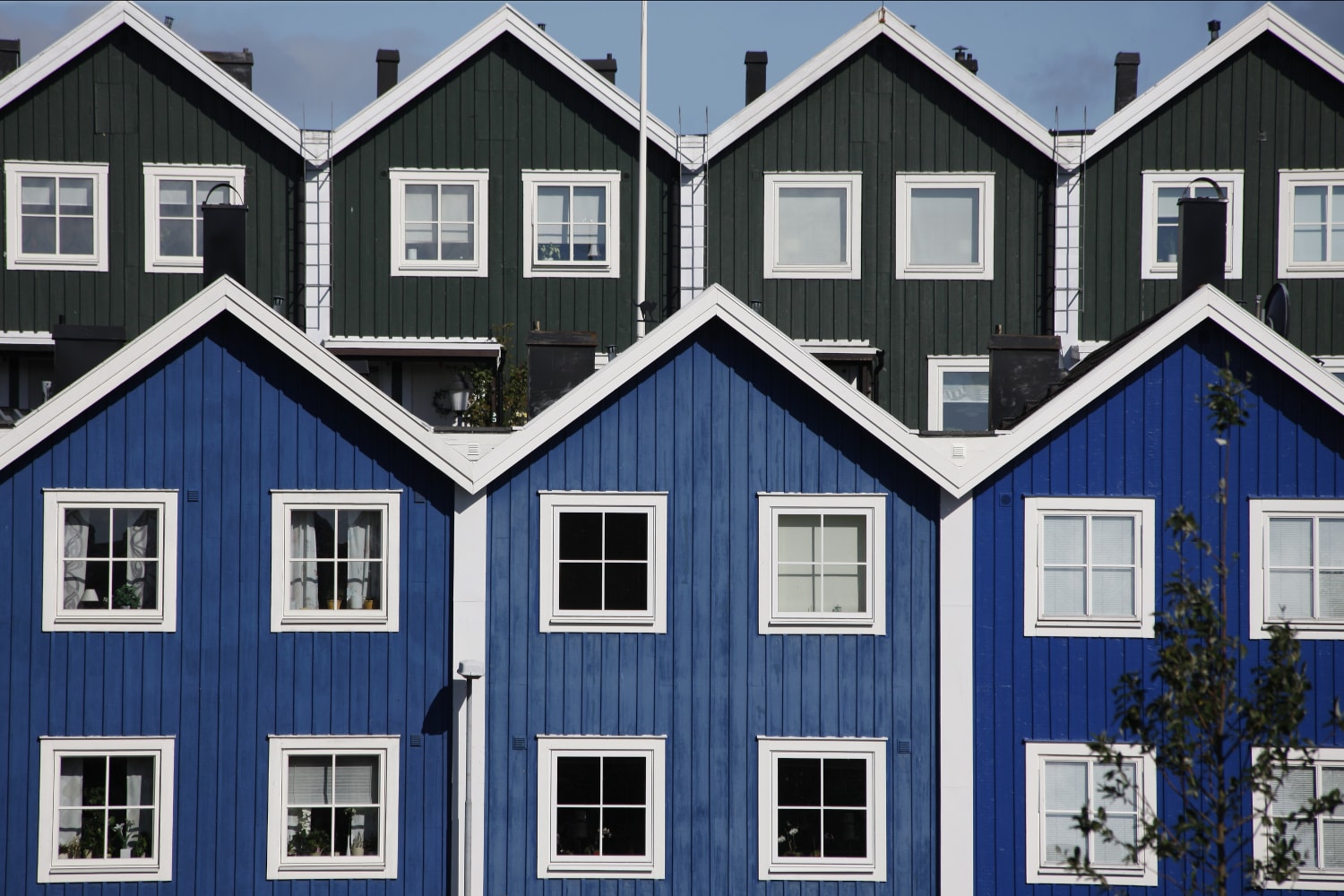 Blå och gröna radhus en solig dag